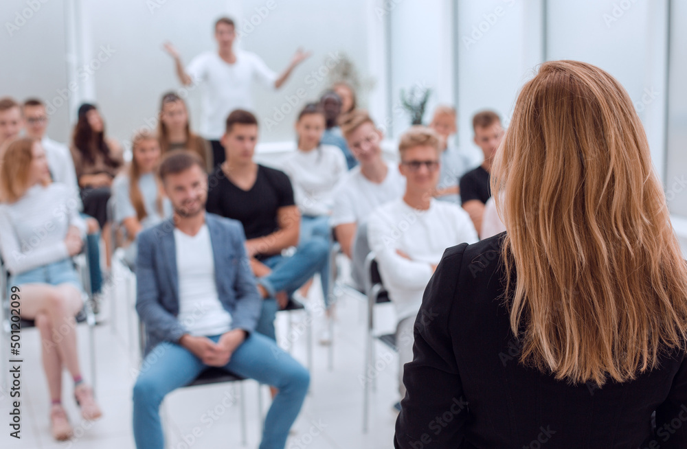 rear view. female speaker giving a lecture in the conference room. rear view. female speaker giving a lecture in the conference room.