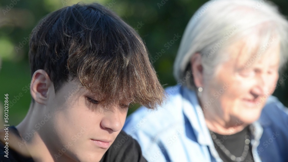 Young boy relaxing oudoor with his grandmother Young boy relaxing oudoor with his grandmother