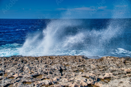 Sea water spray of crushing waves against rocks