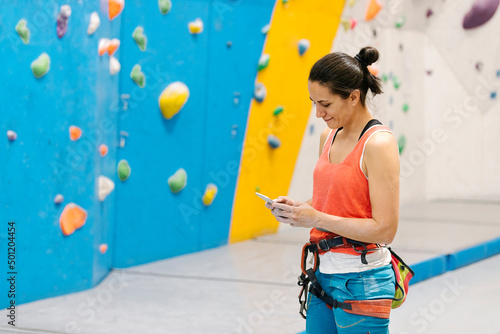 Rock climber woman looking at smartphone.