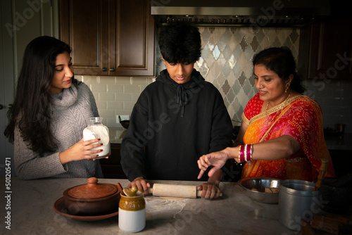 Mother teaching son how to make roti - breaking gender roles  photo