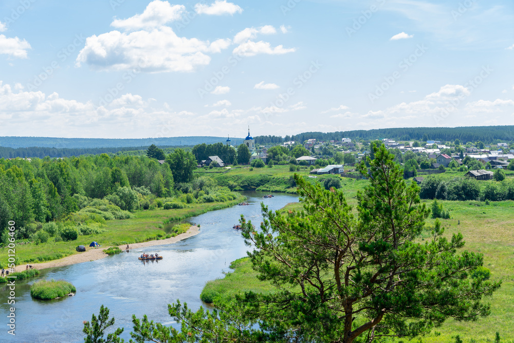View of the Chusovaya river through trees on a sunny summer day, Ural, Sverdlovsk region, Russia. Rafting and active lifestyle