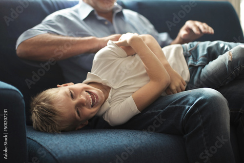 grandfather tickles his grandson