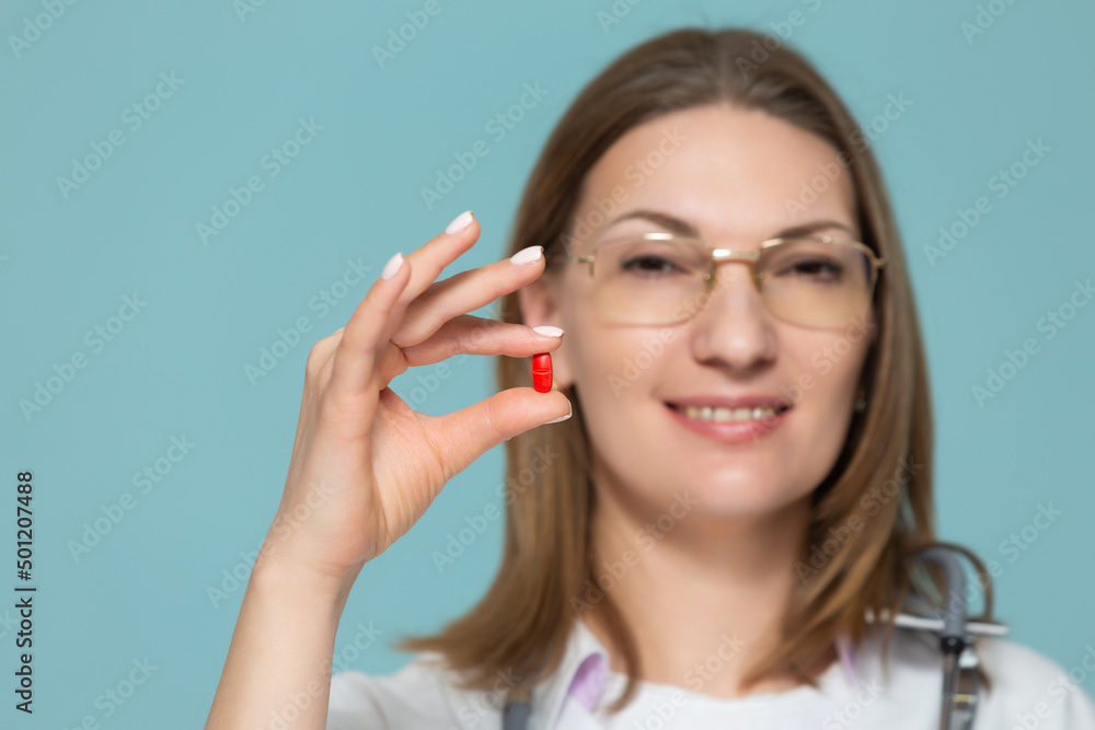 Woman doctor shows medication, on a blue background. Copy paste. healthcare concept. Woman doctor shows medication, on a blue background. Copy paste. healthcare concept.