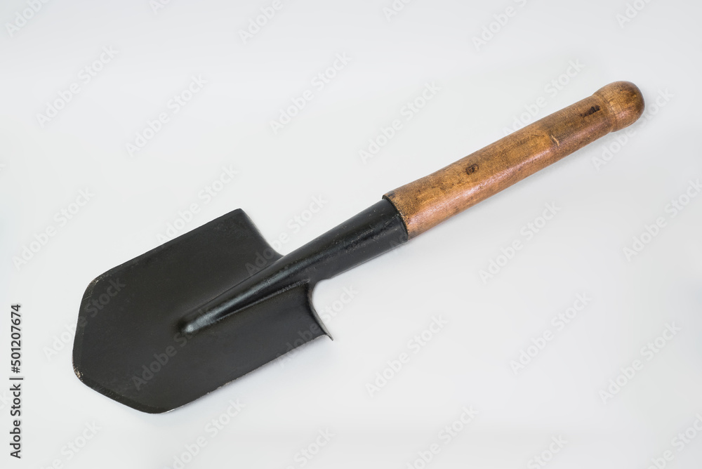 Close-up of a sapper shovel with a wooden handle isolated on a white background.