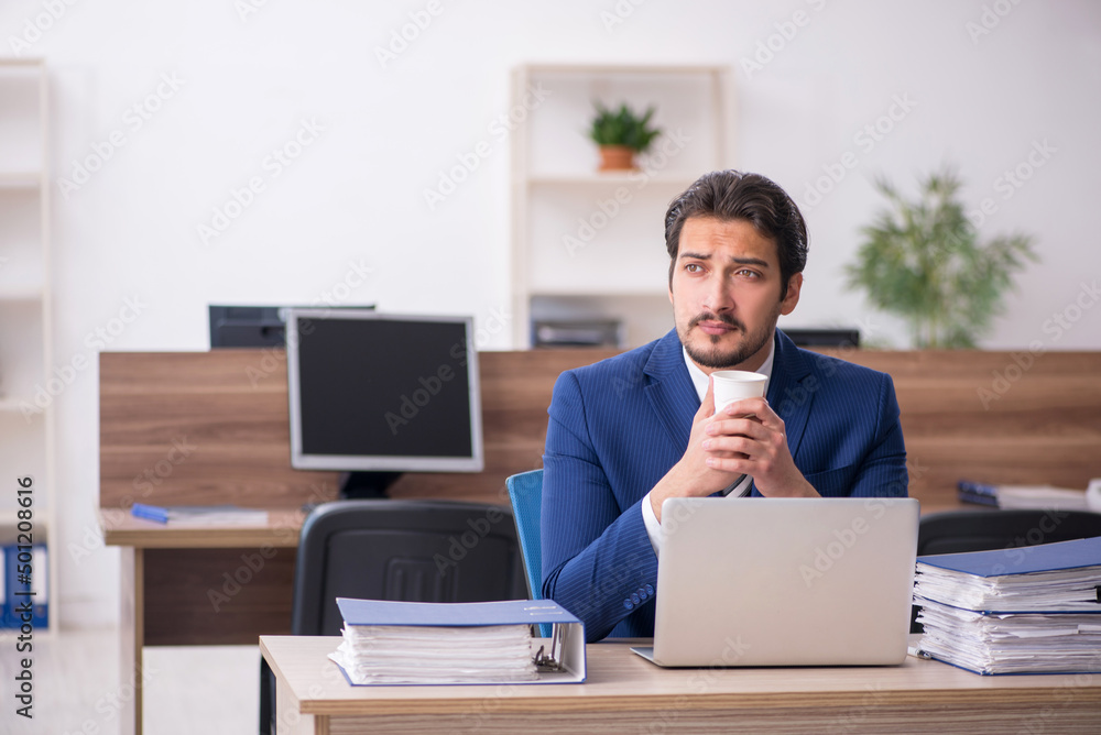 Young male employee drinking coffee during break Young male employee drinking coffee during break