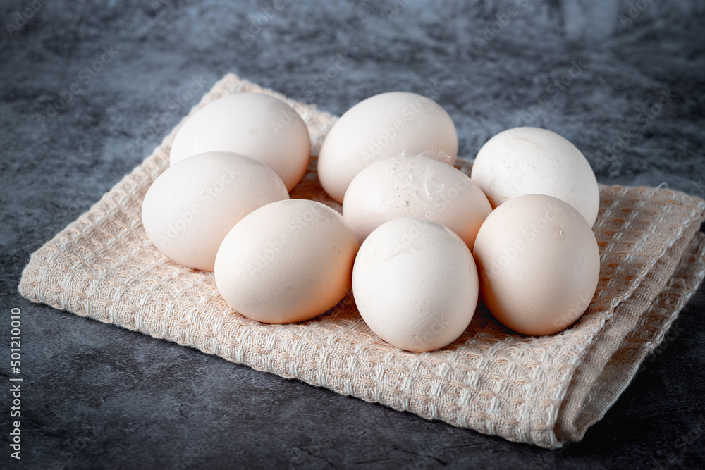 Chicken eggs on beige towel on grey background Chicken eggs on beige towel on grey background