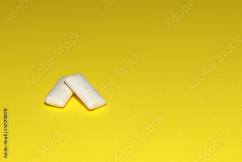 two white gum pads on a yellow background
