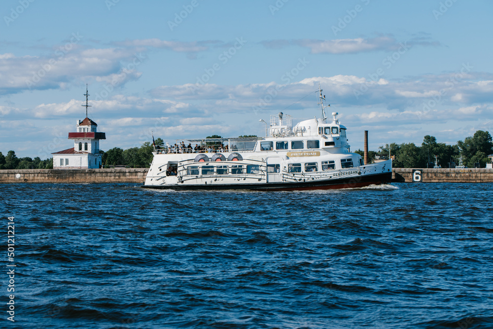A tourist or excursion ship sails in the waters of the Gulf of Finland to the forts in Kronstadt, Petrovskaya Harbor, Kotlin Island