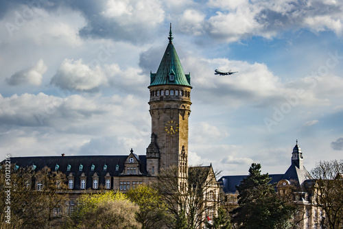 A Plane Coming in for a Landing at the Luxembourg Airport Flies Past the Spuerkeess Bank Clock Tower in Luxembourg City, Luxembourg