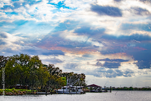 Sunlight Breaks through the Clouds and Turns Them Pink as It Shines Down on the Boats and Bayou Waters in Lafitte, Louisiana, USA
