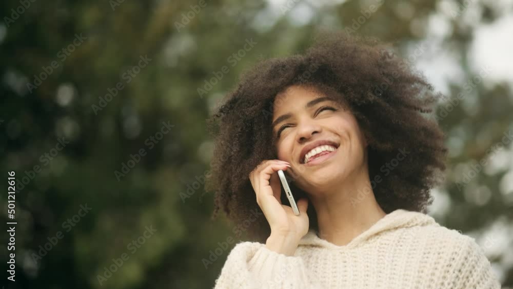 Portrait of attractive African American girl having phone talk. Young beautiful girl at the city street. Happy smiling girl walking forward. High quality 4k footage Portrait of attractive African American girl having phone talk. Young beautiful girl at the city street. Happy smiling girl walking forward. High quality 4k footage