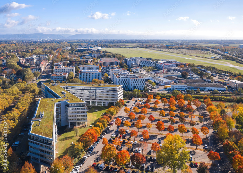 Mannheim cityscape, Germany. Autumn aerial view over office center, car parking and Park at technology museum in Fahrlach district, city airport on the background.