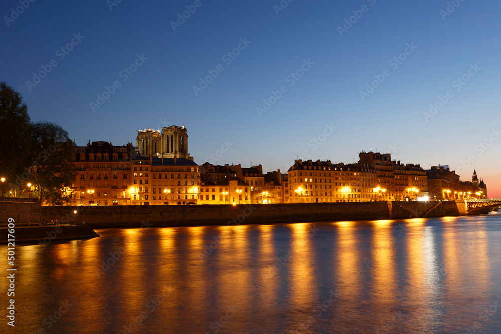 Embankment of the Seine near the Ile de la Cite at night, Notre Dame in the background, Paris.