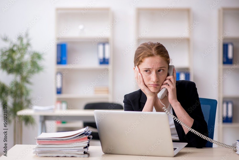 Young female employee working in the office Young female employee working in the office