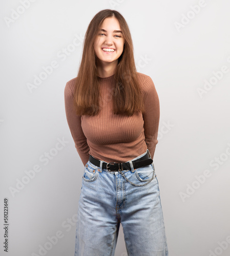 Pretty smiling thinking young natural woman with brunette long hair in casual dress looking happy. Studio shot of good looking beautiful woman