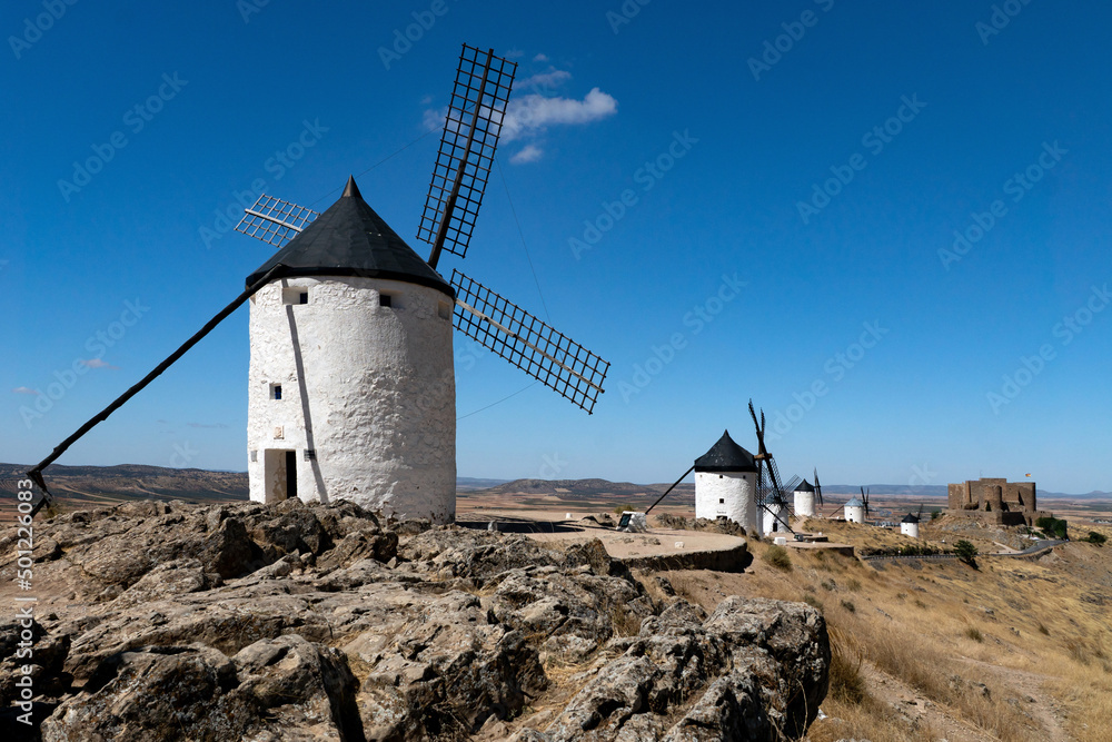 Traditional white windmills on the top of the hill in Consuegra, Spain, in a sunny day.