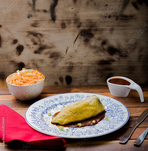Poblano pepper breaded with egg and flour stuffed with minced meat and accompanied by a portion of rice and extra red sauce.