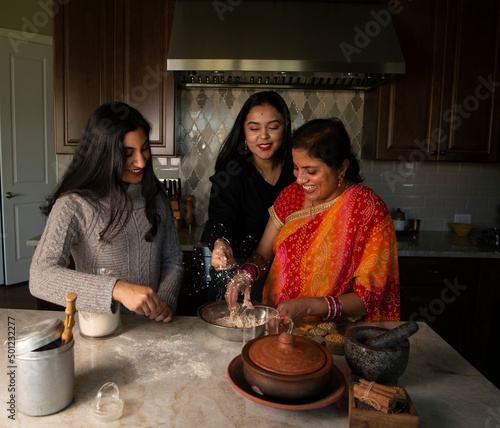 Mother and daughters in the kitchen - having fun  photo
