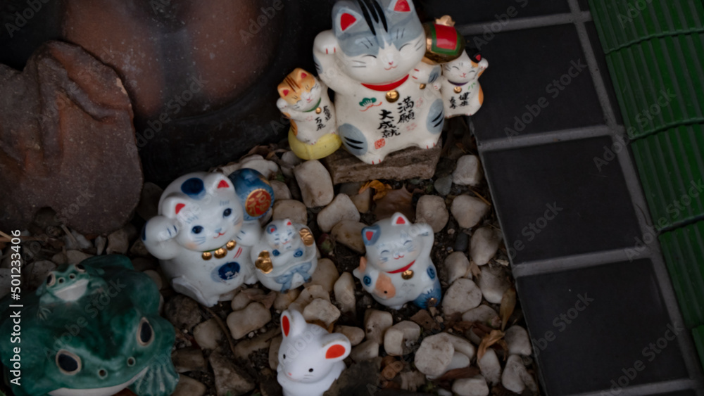 Maneki neko cat dolls displayed in front of soba noodle shop in Japan