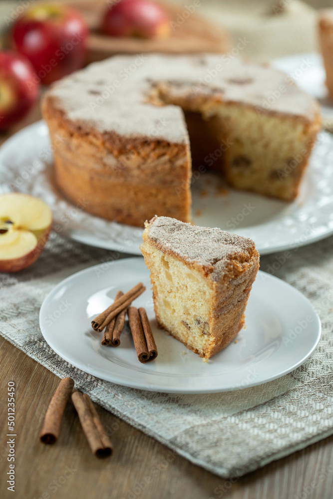 piece of Sponge cake or chiffon cake with apples so soft and delicious sliced with ingredients: cinnamon, eggs, flour, apples on wooden table. Home bakery concept for background and wallpaper piece of Sponge cake or chiffon cake with apples so soft and delicious sliced with ingredients: cinnamon, eggs, flour, apples on wooden table. Home bakery concept for background and wallpaper
