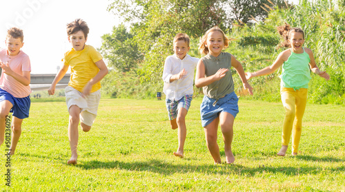 Cheerful children jogging together in the park and having fun
