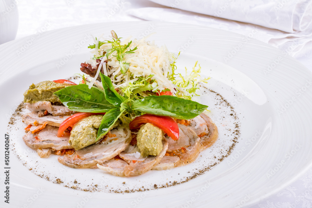 sliced chicken roll with vegetables and mashed avocado on a white plate macro close up sliced chicken roll with vegetables and mashed avocado on a white plate macro close up