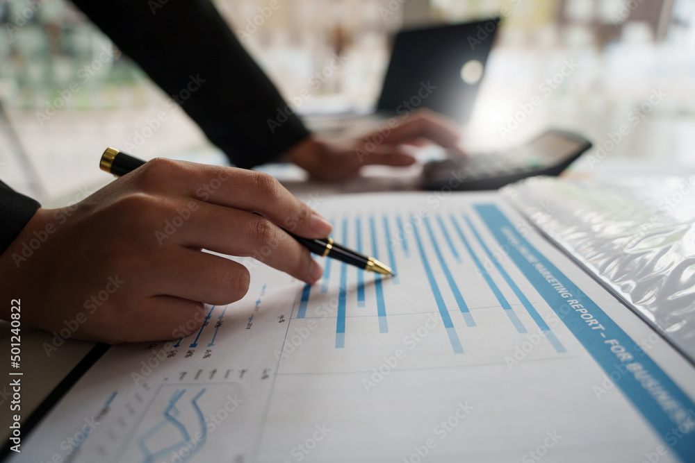 Naklejka premium Close up Businessman hand holding pen and pointing at financial paperwork with social network diagram..