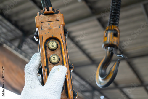 Industrial control buttons. hand holding overhead cranes remote. Up Down hydraulic controller switch. electric remote push button switch of hoist lift or crane for control direction. photo