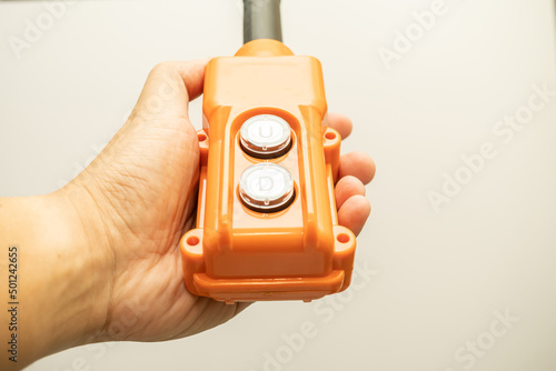 Hoist push button switch in isolated. hand holding overhead cranes remote. Up Down hydraulic controller switch. electric remote push button switch of hoist lift or crane for control direction.