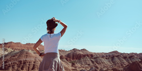rear view of female asian tourist looking at the yardang landforms in national park photo
