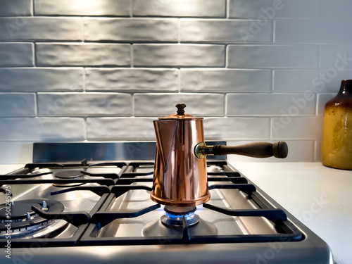 Fotografie, Obraz Copper Turkish coffee pot on stove