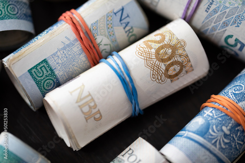 Close-up view of multiple banknotes rolled up. Various denominations of the Polish national currency.