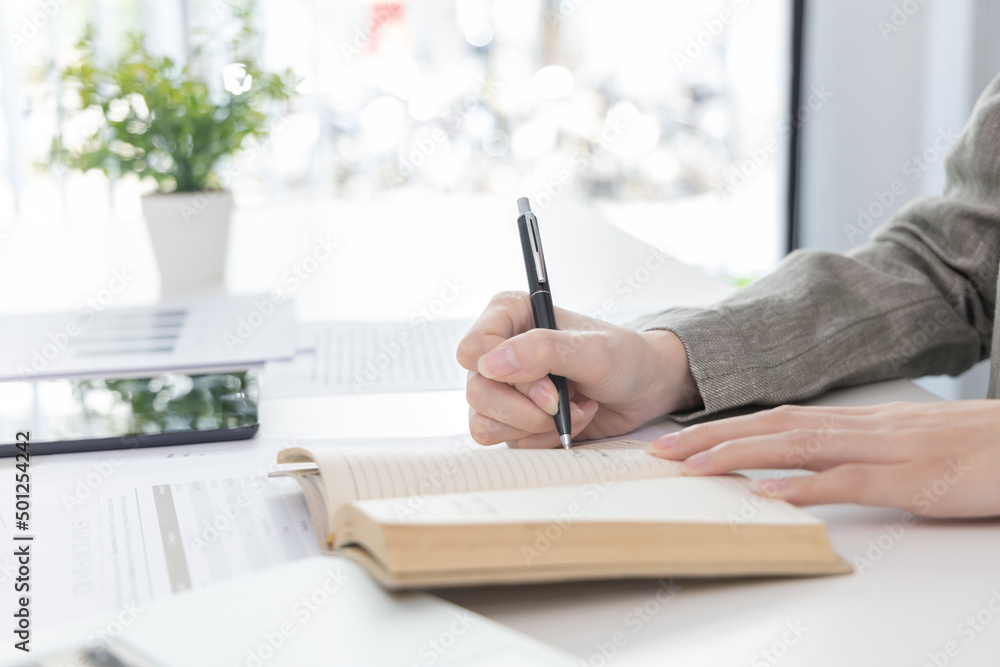 Head of marketing is recording the company's financial growth statistics using graphs as a reference for reviewing and analyzing the results, Taking notes and analyzing data graphs in office. Head of marketing is recording the company's financial growth statistics using graphs as a reference for reviewing and analyzing the results, Taking notes and analyzing data graphs in office.