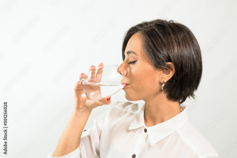 young Latin American woman drinking water from a glass young Latin American woman drinking water from a glass