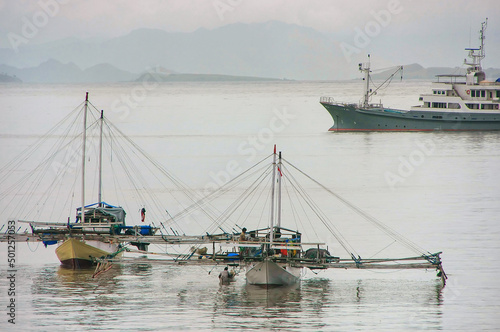 Traditional outrigger boats anchored at Labuan Bajo town on Flores Island, Nusa Tenggara, Indonesia photo