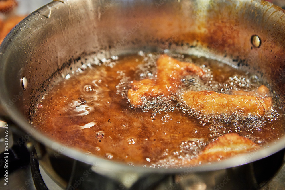 Bugnes, French donuts in boiling oil in saucepan Bugnes, French donuts in boiling oil in saucepan
