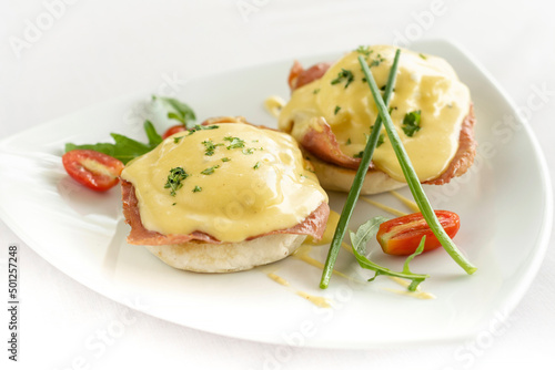 eggs benedict breakfast with ham and hollandaise sauce photo