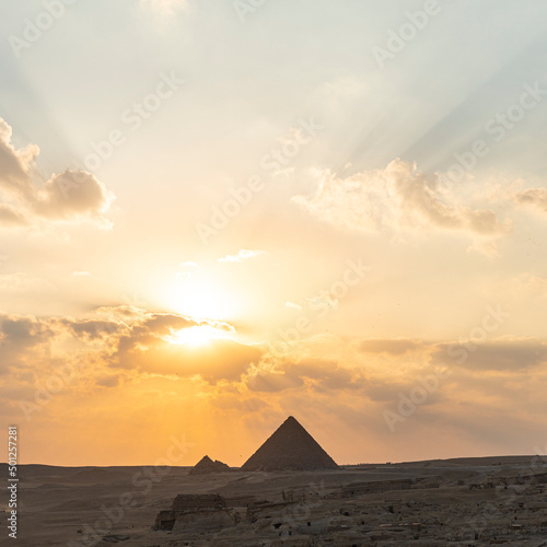 Archaeological complex of Great Egyptian Pyramids is located on the Giza plateau. second pyramid of Chephren khefren in the night light at sunset. sun sets behind the pyramid. photo