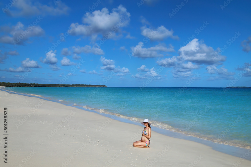 Pregnant woman sitting at Fayaoue beach on the coast of Ouvea lagoon, Mouli and Ouvea Islands, New Caledonia Pregnant woman sitting at Fayaoue beach on the coast of Ouvea lagoon, Mouli and Ouvea Islands, New Caledonia