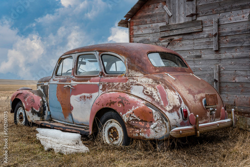 An abandoned multicoloured sedan on the prairies in Saskatchewan