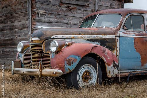 An abandoned multicoloured sedan on the prairies in Saskatchewan