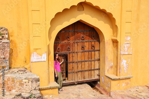 Young woman standing by the gate in Amber Fort near Jaipur, Rajasthan, India