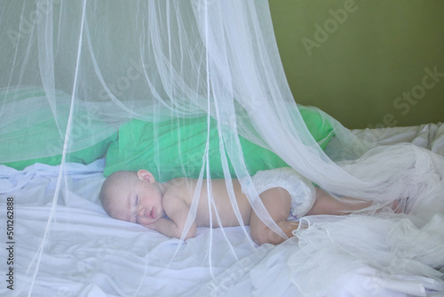Baby girl sleeping under mosquito net