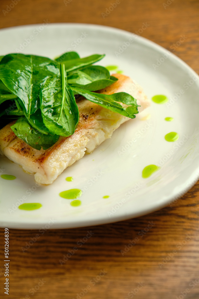 Pike perch fish fillet with spinach leaves