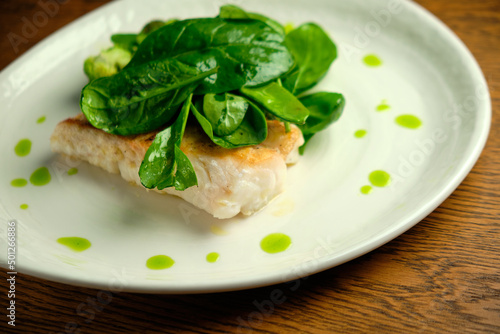 Pike perch fish fillet with spinach leaves