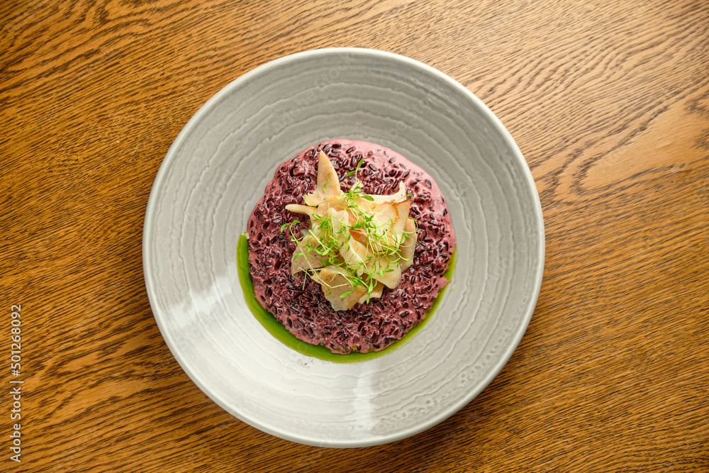 Risotto on a white restaurant plate with cuttlefish ink Risotto on a white restaurant plate with cuttlefish ink
