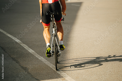 Fototapeta Naklejka Na Ścianę i Meble -  Legs of a man riding his street racing bike on a road through