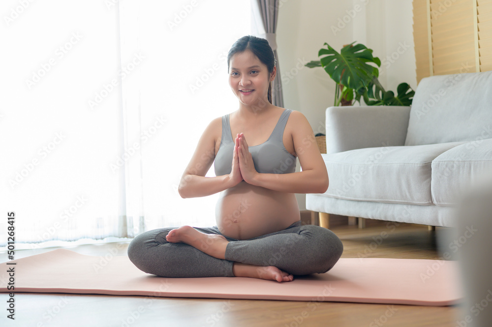 Young pregnant woman doing yoga at home, healthcare and pregnancy care concept Young pregnant woman doing yoga at home, healthcare and pregnancy care concept