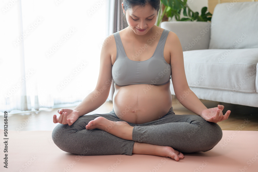 Young pregnant woman doing yoga at home, healthcare and pregnancy care concept Young pregnant woman doing yoga at home, healthcare and pregnancy care concept